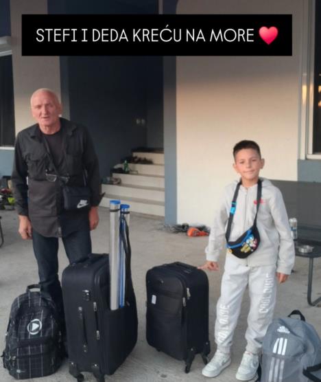 Stefan sa dekom stoji pored kofera