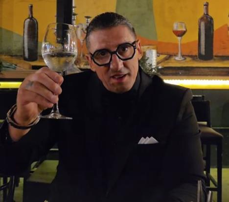 Kristijan Golubović u crnom odelu pije kiselu vodu