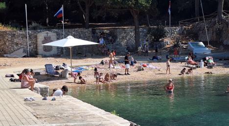 Ljudi se sunčaju i kupaju na plaži