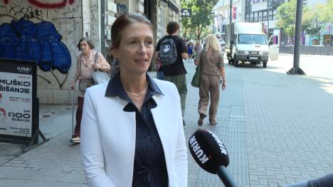 žena u belom sakou na ulici