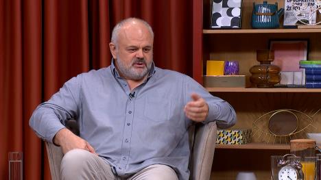 Sedi čovek u sivoj košulji na fotelji