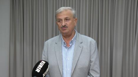 Čovek u sivom odelu sa sivom pozadinom