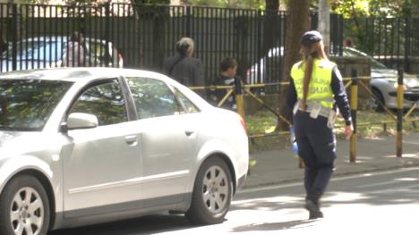 Policajka na ulici pored sivog automobila