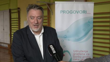 Čovek u crnom sakou u sali za fiičko