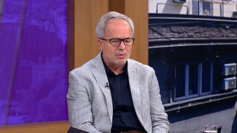 Čovek u sivom odelu sa naočaraa