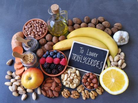 voće banane jabuke orašasti plodovi postavljeni na stoplu uz natpis na engleskom snižva trigliceride