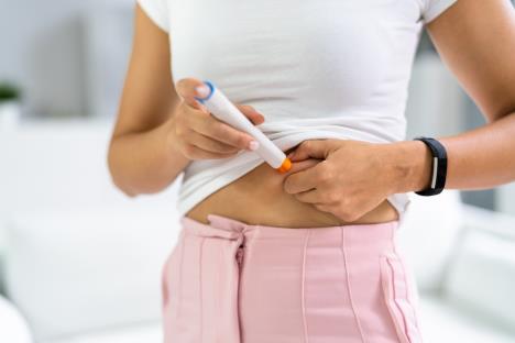 mlada žena daje sebi insulinsku terapiju pomoću injektora