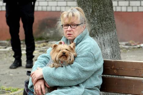 penzionerka drži psa u rukama na klupici