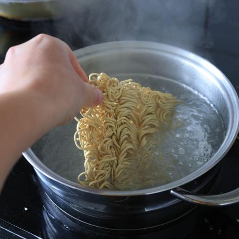 Žena ubacuje nudle u šerpu kipuće vode