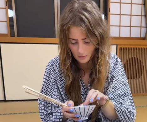 Turistkinja u japanu jede pirinač štapićima