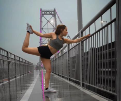 Ana Nikol Gomes radi jogu na pešačkom mostu.jpg