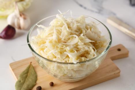 Kupus salata u staklenoj činiji na drvenoj dasci