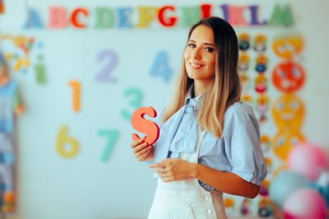 žena logoped drži model slova S