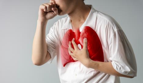 mladić koji kašlje se drži za pluća koja su označena crvenom bojom