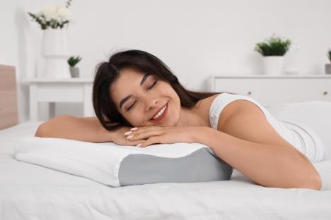 devojka leži na krevetu a glavu drži oslonjenu na jastuk