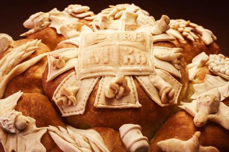 Okrugli slavski kolač ukrašen tradicionalnim simbolima i krstom