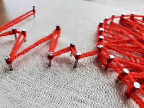 srce sa otkucajima istkano od crvenog konca, detalj