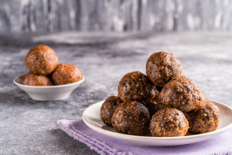 Kuglice od oraha i smokvi servirane na tanjiru sa ljubičastom krpom