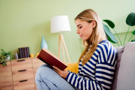 devojka sedi u zelenoj sobi i čita knjigu