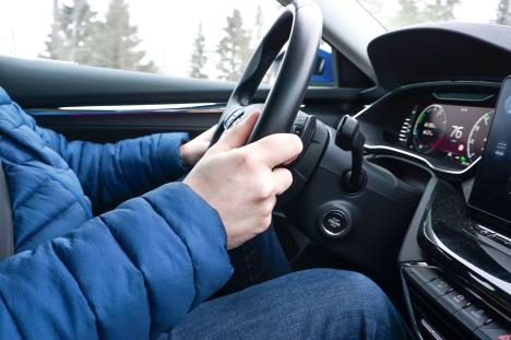 Osoba u plavoj zimskoj jakni vozi auto