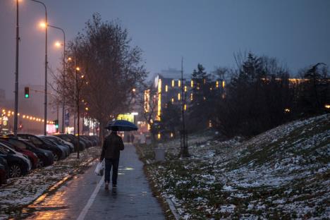 Čovek sa kišobranom šeta po snegu