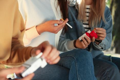 mlade devojke sede i dele cigarete