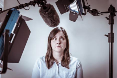 žena u strahu od javnog nastupa okružena kamerama