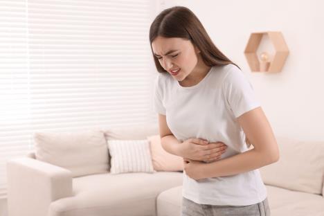 Mlada devojka se drži za stomak zbog bolova