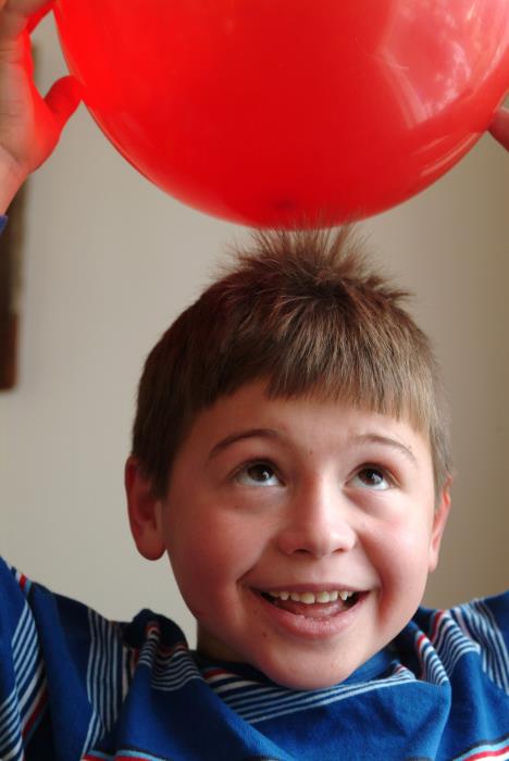 Dečak naelektrisane kose sa crvenim balonom iznad glave