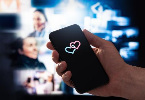 Ruka drži mobilni telefon sa dva srca na ekranu