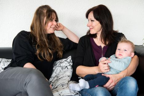 Svekrva drži dete dok priča sa snajkom