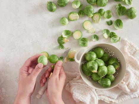 žena secka prokelj i stavlja ga u posudu za pranje