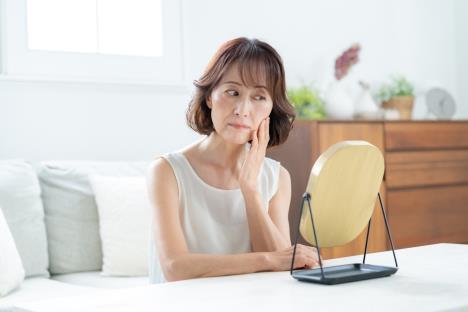 žena u srednjim godinama gleda bore u ogledalu