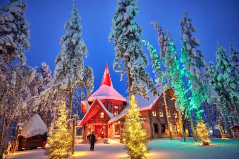 Božićno selo u Rovaniemiju sa drvenim kućicama, irvasima i svetlima na Arktičkom krugu, simbol prazničnog veselja i obnove grada