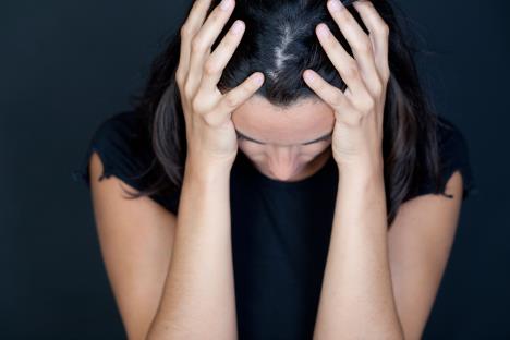 Tužna žena se drži rukama za glavu