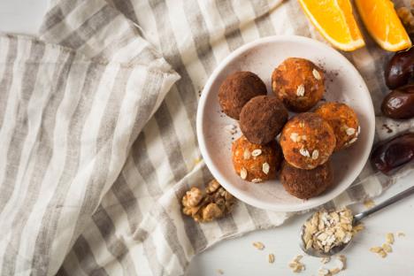 čokoladne kuglice sa pomorandžom u belom tanjiru na prugastoj lanenoj krpi sa sastojcima