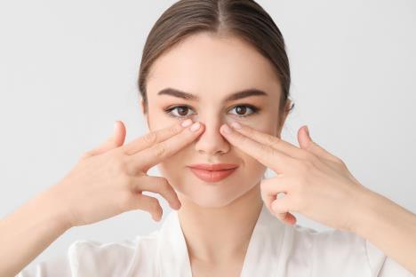 devojka pokazuje prstima na nos