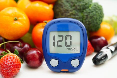 merač šećera u krvi sa zdravim namirnicama u pozadini