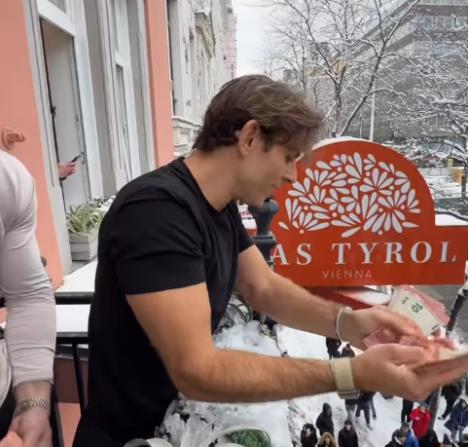 Influenser baca novac među prolaznike na Marijahilferštrase u Beču tokom promotivne akcije