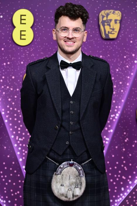 Luk Angus na crvenom tepihu BAFTA nagrada u škotskom kiltu i smoking-sakou