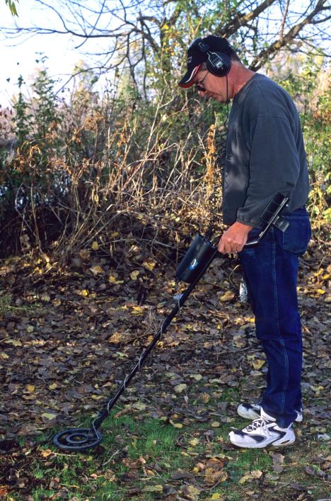 Muškarac pretražuje zemlju detektoro za metal