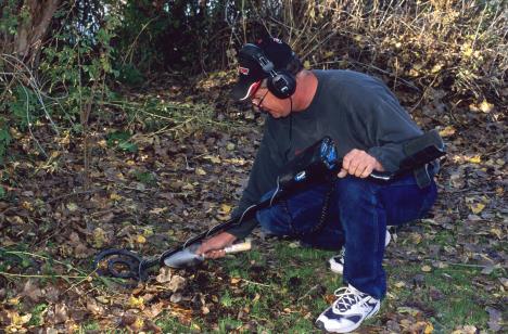Muškarac detektorom za metal pretražuje zemljište