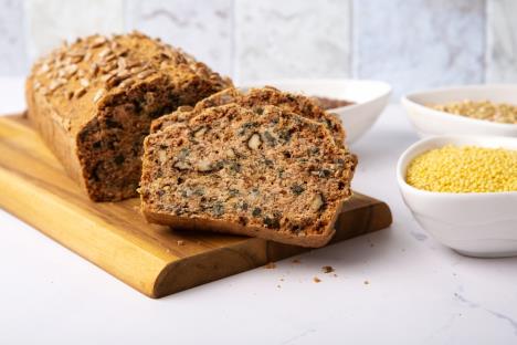 domaći hleb od kinoe sa semenkama na drvenom pladnju, sastojci u činijama na stolu