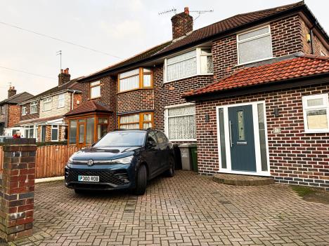 Plavi auto parkiran u dvorištu ispred kuće