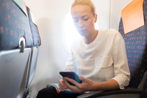 žena koristi telefon u avionu pre poletanja