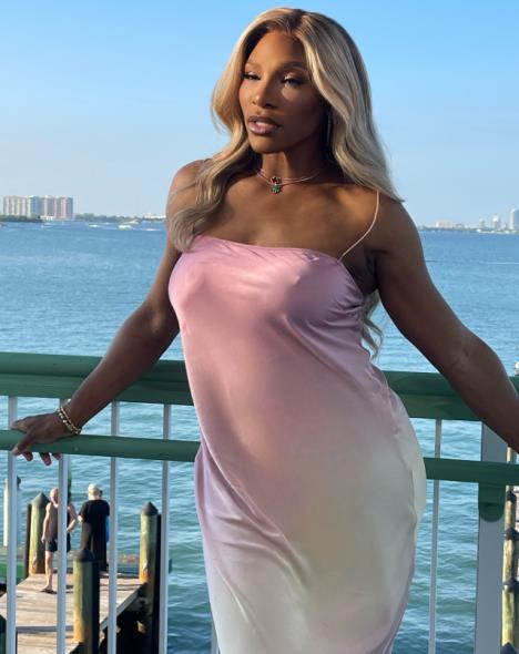 Serena Vilijams u ružičastoj haljini na balkonu sa pogledom na more.PNG