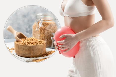 žena sa crvenim balonom ispred stomaka, koncept nadutost/heljda