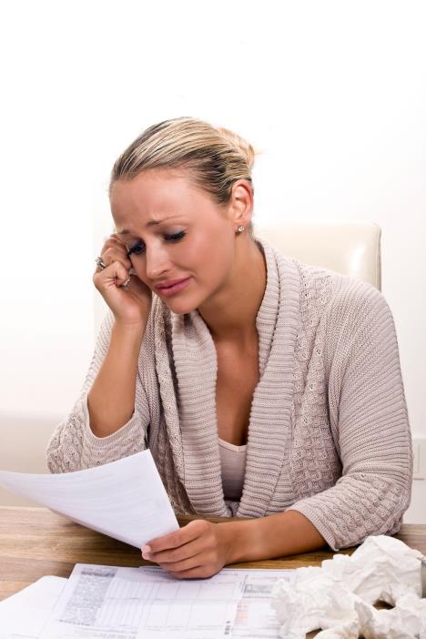 Tužna žena za stolom čita pismo