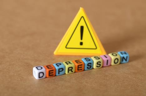 ispis depresija na plastičnim kockicama složenim pored žutog trougla sa znakom uzvika