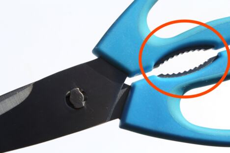 Makaze sa nazubljenim zubićima između drški i sečiva